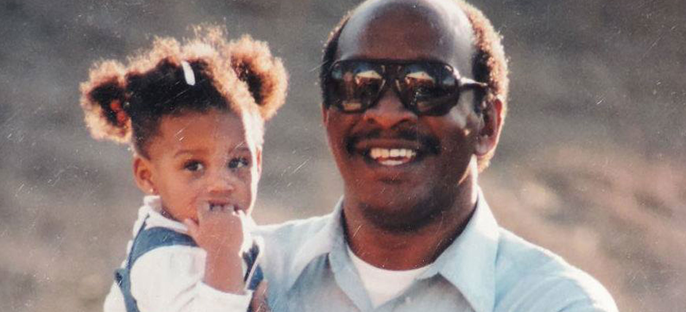 A grandpa holding his granddaughter and posing for a photo.